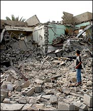Young Iraqi boy examines rubble at a bombing site in Falluja