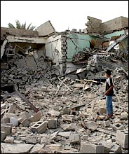 Young Iraqi boy examines rubble at a bombing site in Falluja