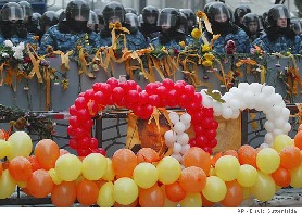 Riot police stand behind balloons and a portrait of opposition candidate Viktor Yushchenko